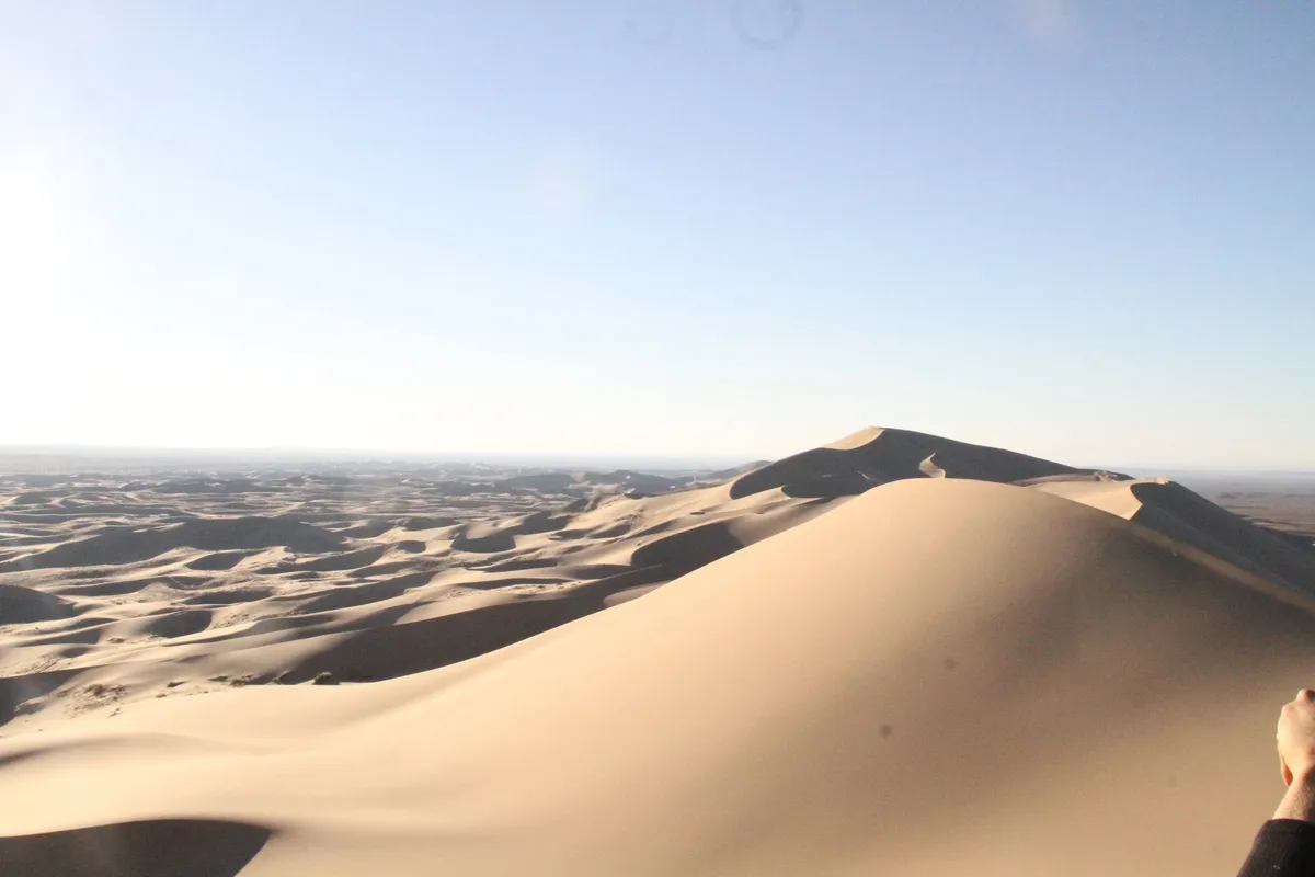 A large dune ridge rising above a sea of smaller dunes