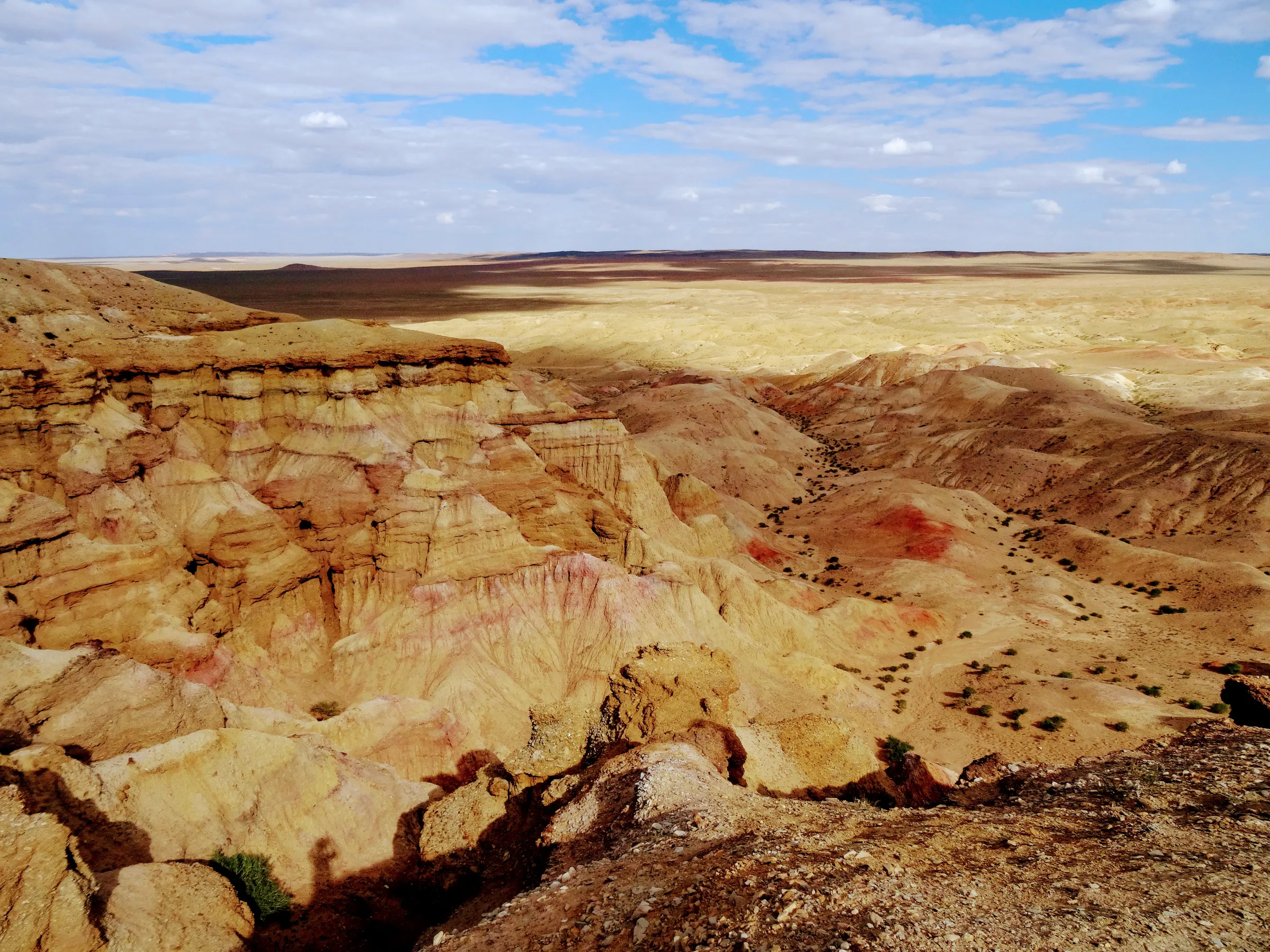 Layered badlands under low sun