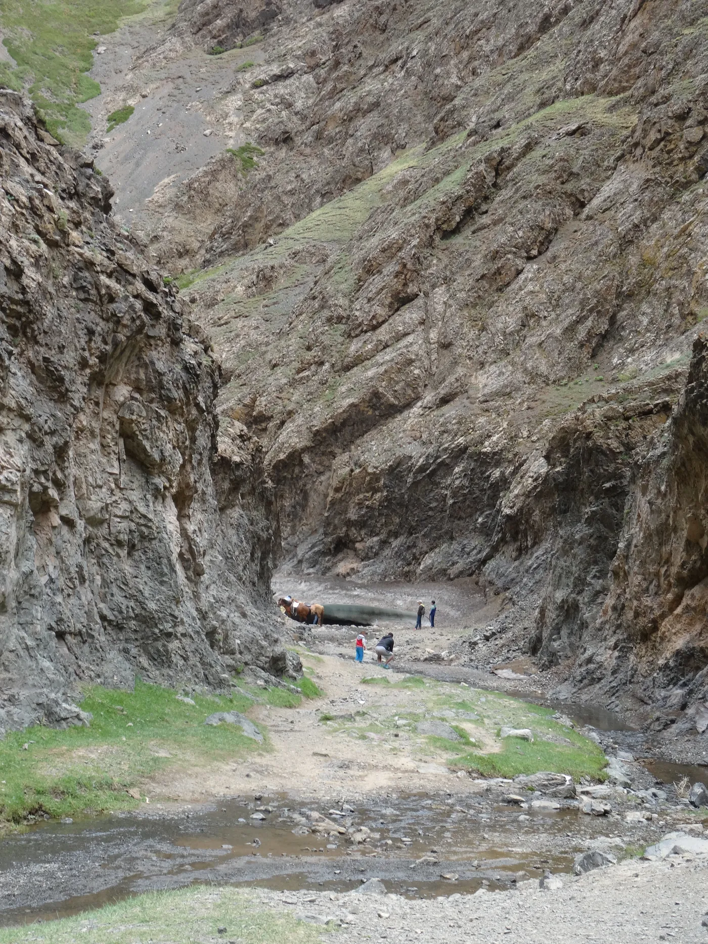 Walkers dwarfed inside a narrow gorge