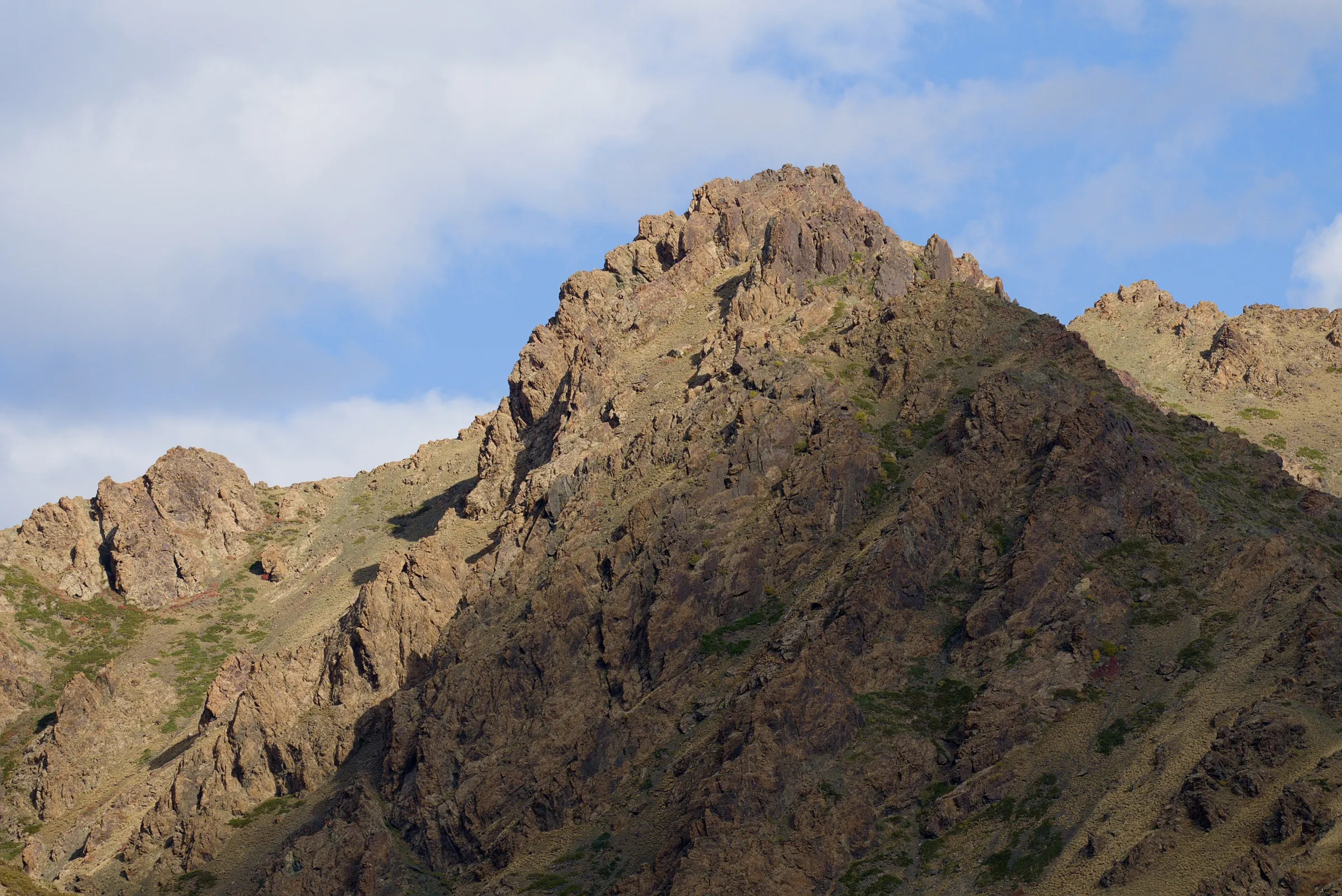 A rocky ridge of the Gurvan Saikhan mountains under a blue sky