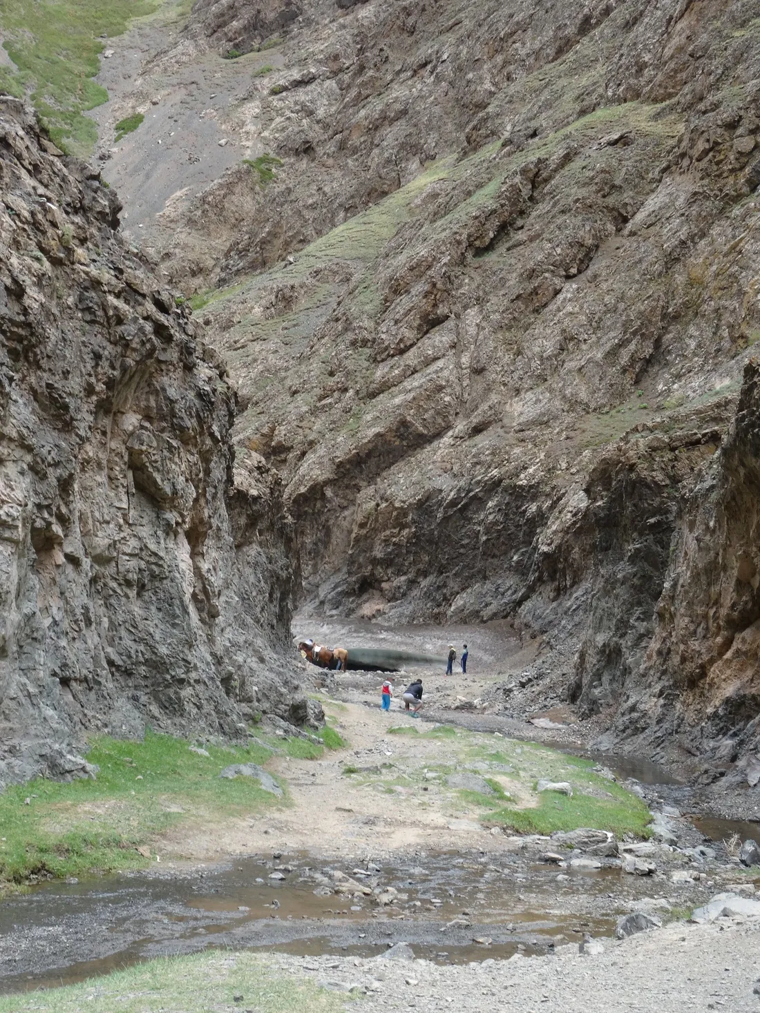 Walkers dwarfed inside a narrow gorge