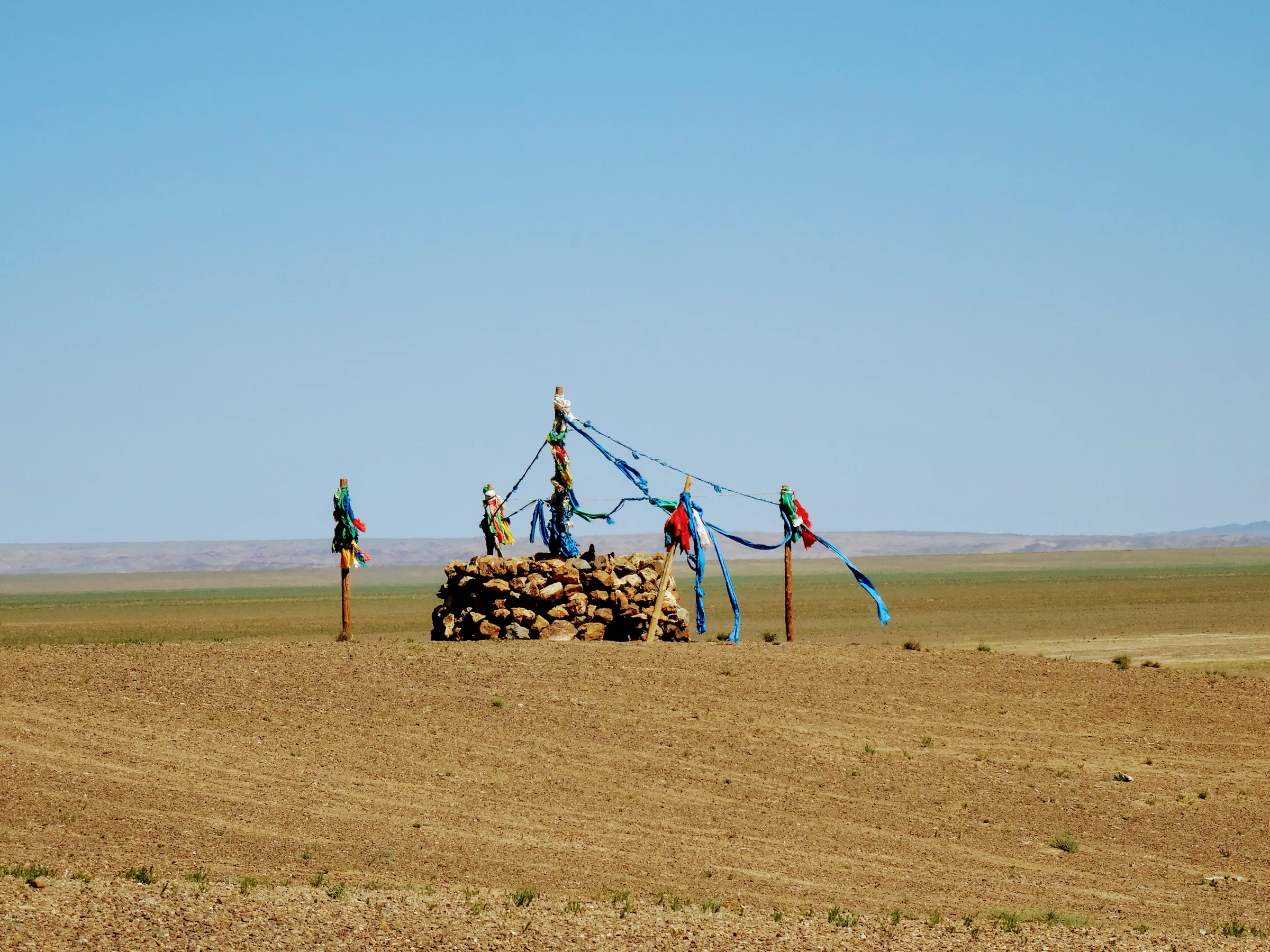 Prayer flags on a cairn against an open sky