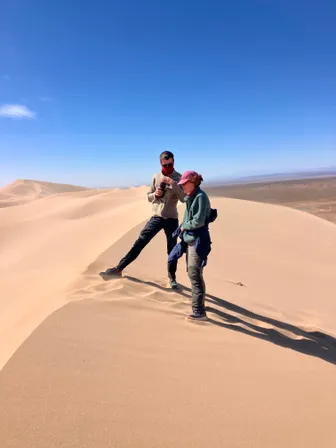 Two travellers standing on the ridge of a sand dune