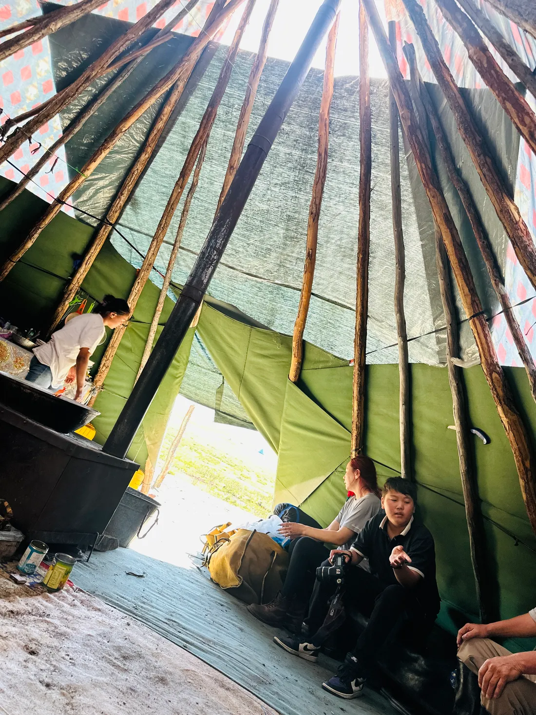 Looking up at the poles inside a teepee