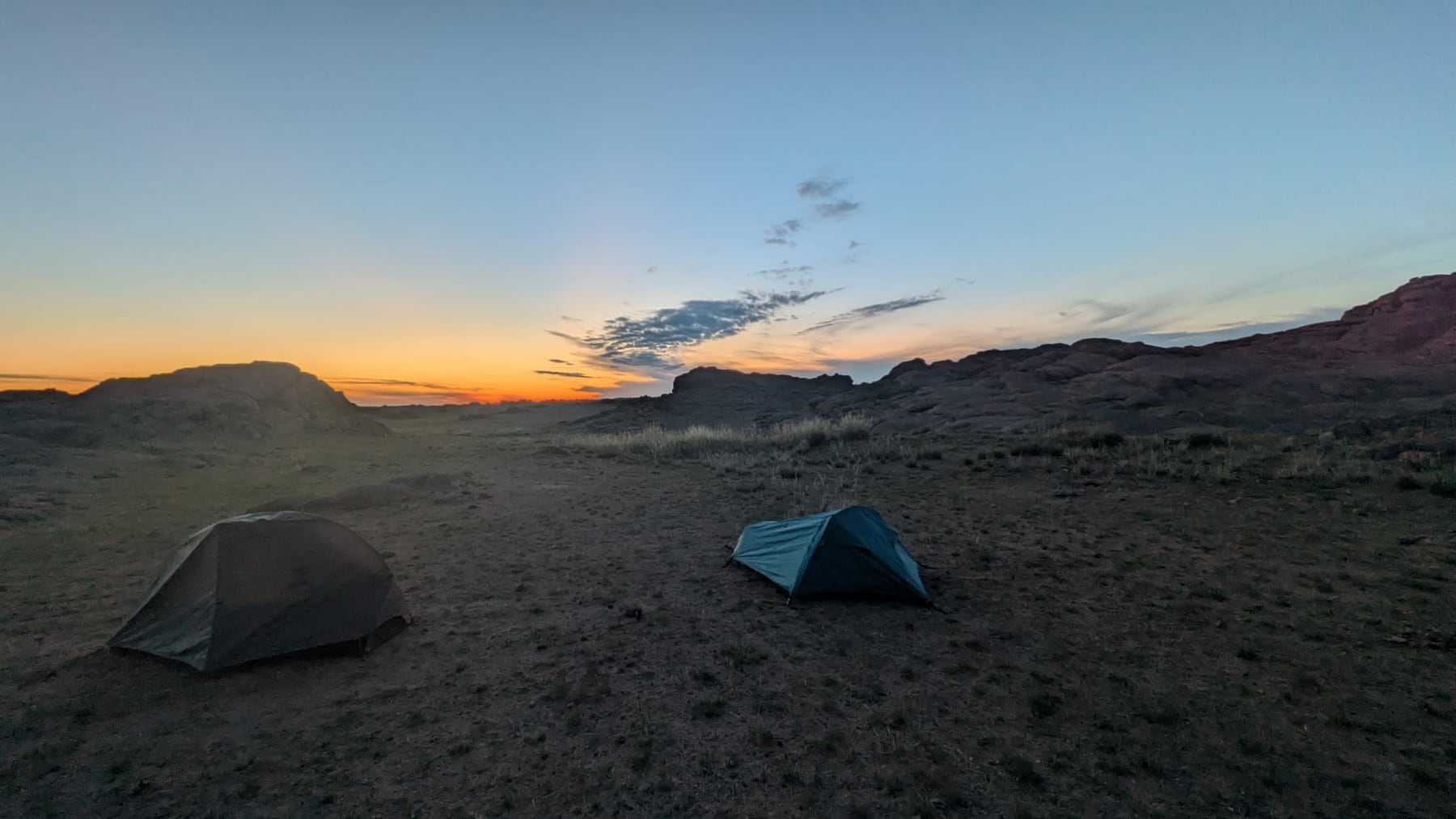 Two tents pitched on open ground at Ikh Gazariin Chuluu at dusk